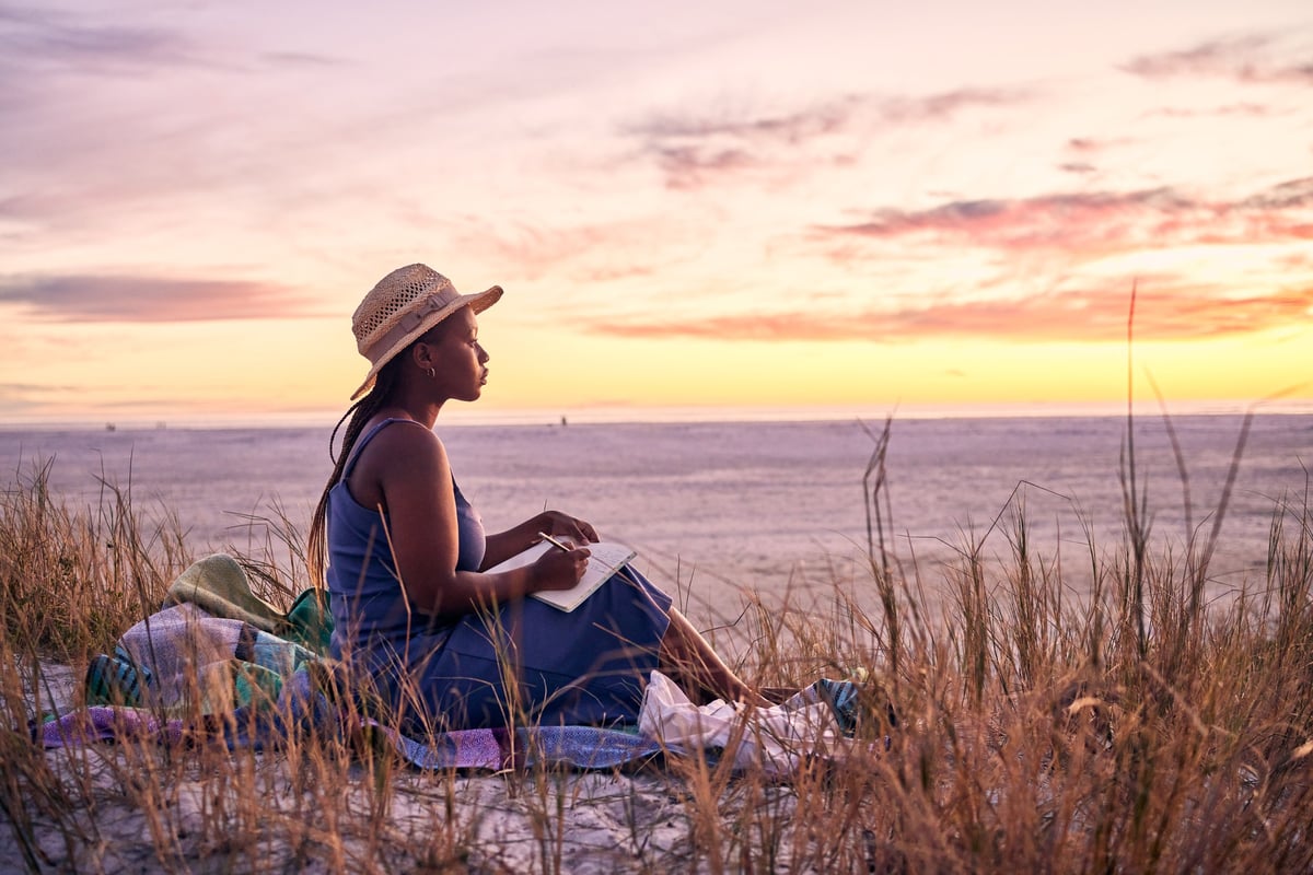Woman walking on beach at sunrise embracing freedom and new beginning