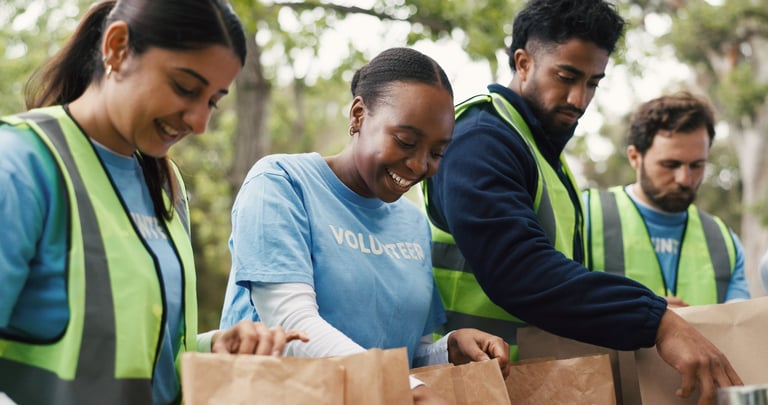 Outdoor, volunteers and group with donations, charity or happy for community service with food boxes.